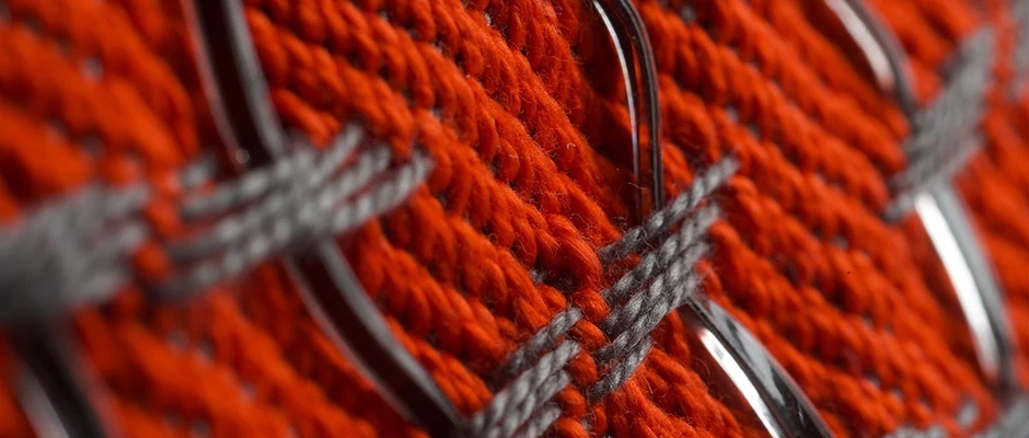 close up of fabric interwoven with wiry looking strings.