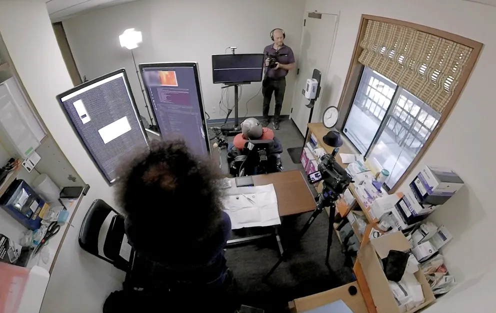 Paralyzed man using an electrode set up to communicate with words displayed on a screen.
